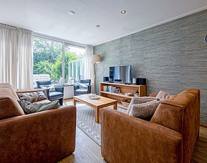 Cozy living room of Holiday home Slufterhoek 132 in De Cocksdorp, Texel with comfortable sofas and views of nature.