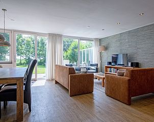 Bright dining room and living room in Holiday home Slufterhoek 132, De Cocksdorp, Texel overlooking the green surroundings.