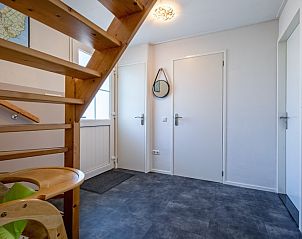 Entrance to Holiday home Slufterhoek 132 in De Cocksdorp, Texel with wooden stairs and practical layout.
