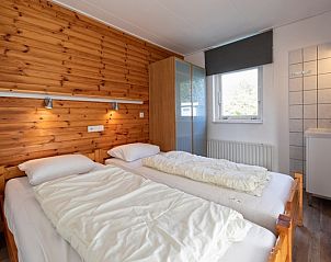 Sfeervolle slaapkamer in Bungalow Tamarisk 190, De Cocksdorp Texel, met houten accenten en veel natuurlijk licht.