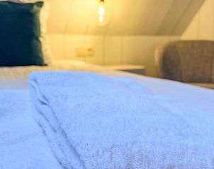 Comfortabele bedden in Vakantiehuis in De Cocksdorp, Texel met zachte handdoeken.