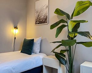 Eenpersoonskamer in Vakantiehuis in De Cocksdorp, Texel met groene plant.