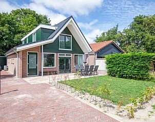 Vakantiehuis Slufterhoek 104 in De Cocksdorp op Texel biedt een charmante buitenkant met terras en groene omgeving.