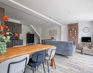 Stijlvolle eetkamer in Vakantiehuis Slufterhoek 104, De Cocksdorp, Texel met houten tafel en moderne keuken.