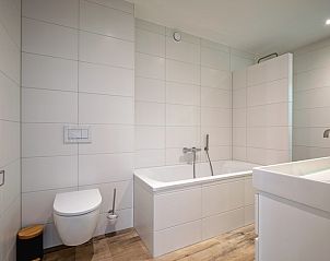 Ruime badkamer in Vakantiehuis Slufterhoek 104, De Cocksdorp, Texel met ligbad en moderne afwerking.