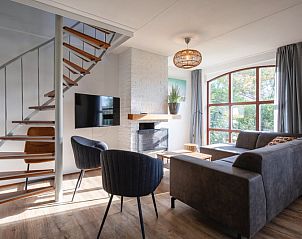 Gezellige woonkamer in Villapark Residentie Texel nr. 711, vakantiehuis in De Cocksdorp, Texel met moderne inrichting en grote ramen.