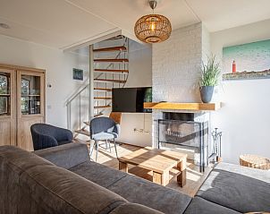 Gezellige woonkamer in Villapark Residentie Texel nr. 711, vakantiehuis in De Cocksdorp, Texel, met open haard en moderne inrichting.