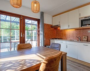 Gezellige keuken en eetruimte in Villapark Residentie Texel nr. 711, vakantiehuis in De Cocksdorp, Texel, met uitzicht op terras en tuin.