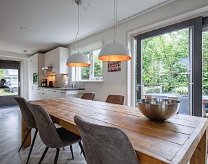 Moderne keuken en eetruimte in Blommetjes Buiten, De Cocksdorp, Texel met uitzicht op groene tuin.