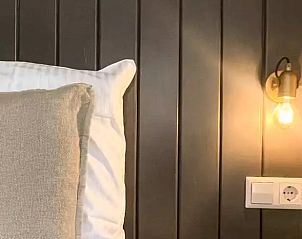 Gezellige slaapkamer in Huisje in De Cocksdorp, Texel, met sfeervolle verlichting en comfortabel bed.