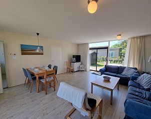 Ruime woonkamer in Bungalowpark Tamarisk - Bungalow 178, De Cocksdorp Texel met uitzicht op de tuin.