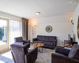 Gemtliches Wohnzimmer des Ferienhauses Schelpenoord 135 in De Cocksdorp, Texel mit bequemen Sofas und viel Tageslicht.