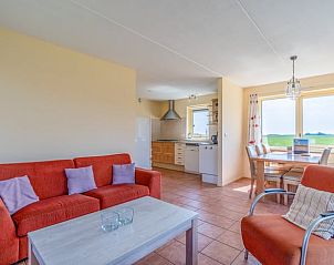 Gezellige woonkamer van Vakantiehuisje in De Cocksdorp, Texel, met open keuken en uitzicht op de groene omgeving van de Waddeneilanden.