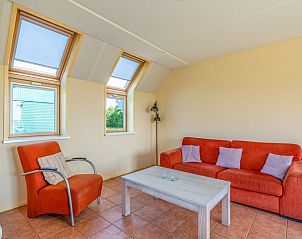 Gezellige woonkamer van Vakantiehuisje in De Cocksdorp, Texel met comfortabele zitruimte en veel natuurlijk licht door dakramen.