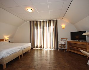 Lichte slaapkamer met balkon in Villa De Witte Hoek serre huisdiervrij, De Cocksdorp Texel, perfect voor ontspannen ochtenden.