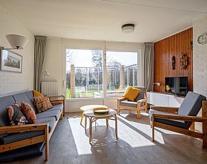 Lichte woonkamer van Vakantiehuis Slufteroord 292 in Bungalowpark Slufteroord, De Cocksdorp, Texel, met uitzicht op de tuin.