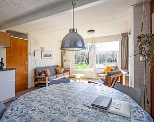 Eetruimte en woonkamer in Vakantiehuis Slufteroord 292, Bungalowpark Slufteroord, De Cocksdorp, Texel, met uitzicht op de tuin.