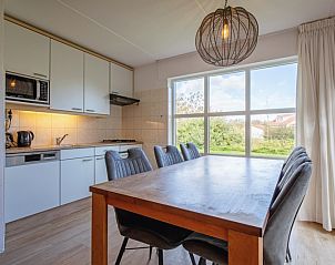 Gezellige eetkamer in Villapark Residentie Texel nr. 469, vakantiehuis in De Cocksdorp, Texel met uitzicht op groene omgeving.