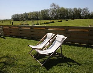 Relax in de ligstoelen van Vakantiehuis in De Cocksdorp, Texel, met uitzicht op groene velden en natuur op de Waddeneilanden.