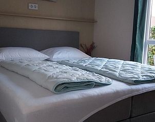 Gezellige slaapkamer in Chalet Duunzicht, een vakantiehuis in De Cocksdorp, Texel, met comfortabel bed en uitzicht op de groene omgeving.