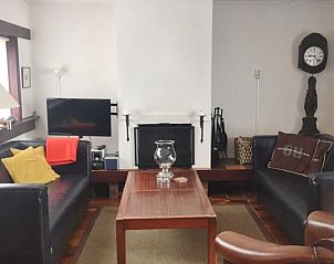 Gezellige woonkamer van Bungalow Slufterduin - De Blauwe Skor in De Cocksdorp, Texel, met comfortabele zithoek en open haard.