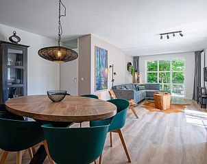 Stijlvolle woonkamer van Vakantiehuis D 690 in De Cocksdorp, Texel. Geniet van het moderne interieur en het uitzicht op de groene omgeving.