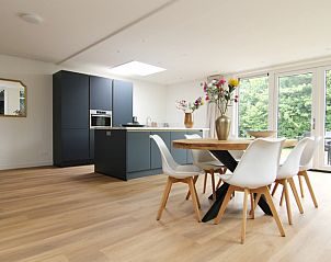 Stylish dining room of Holiday home D 449 in De Cocksdorp, Texel, with modern furnishings and views of green nature.