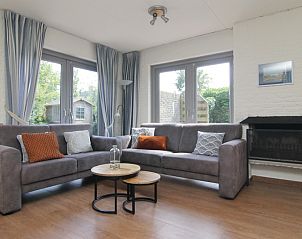 Cozy living room of Holiday home A 249 in De Cocksdorp, Texel, with comfortable seating area and view of green garden.