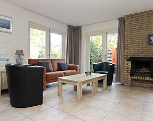 Gezellige woonkamer van Vakantiehuis B 053 in De Cocksdorp, Texel, met comfortabele zitruimte en openslaande deuren naar de tuin.