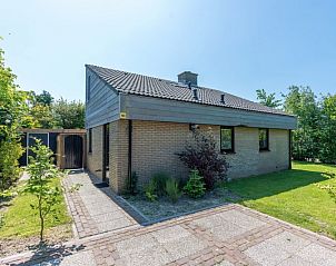 Vakantiehuis A 103 in De Cocksdorp, Texel, biedt een serene buitenruimte met groene omgeving en zonnig terras, ideaal voor ontspanning.