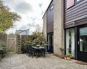 Ontspan op het zonnige terras van Vakantiehuis B 203 in De Cocksdorp, Texel, omringd door groene natuur en rustieke charme.