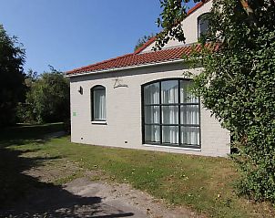 Das Ferienhaus D 603 in De Cocksdorp, Texel, bietet einen ruhigen Auenbereich mit grnem Garten und charmanter Fassade, der zum Entspannen einldt.