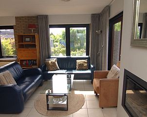 Cozy living room of Holiday home B 163 in De Cocksdorp, Texel. Comfortable seating area overlooking the green garden of the Wadden Islands.