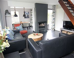 Gezellige woonkamer in Vakantiehuis A 381, De Cocksdorp, Texel. Comfortabele zitruimte met open haard en moderne inrichting op de Waddeneilanden.