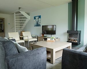 Gezellige woonkamer van Vakantiehuis D 669 in De Cocksdorp, Texel, met moderne inrichting en open haard voor een ontspannen verblijf.