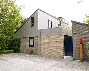 Vakantiehuis C 067 in De Cocksdorp, Texel biedt een charmante buitenkant omgeven door groen, ideaal voor een ontspannen verblijf op de Waddeneilanden.