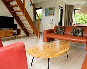 Gezellige woonkamer van Vakantiehuis C 067 in De Cocksdorp, Texel met comfortabele banken en een stijlvolle houten tafel.