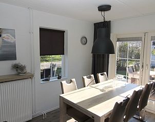 Gezellige eetkamer in Vakantiehuis D 692 in De Cocksdorp, Texel, met uitzicht op de tuin en een ruime eettafel voor familiediners.