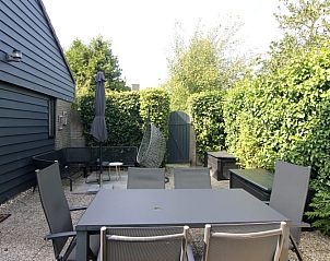 Geniet van de serene tuin van Vakantiehuis B 271 in De Cocksdorp, Texel, met comfortabel terras omgeven door groene natuur.