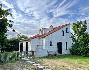 Vakantiehuis D 709 in De Cocksdorp, Texel, biedt een charmant verblijf met rode dakpannen en een groene tuin op de Waddeneilanden.