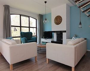 Gezellige woonkamer van Vakantiehuis D 437 in De Cocksdorp, Texel, met comfortabele zitruimte en sfeervolle open haard.