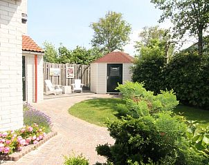 Geniet van de serene tuin van Vakantiehuis D 758 in De Cocksdorp, Texel, met een zonnig terras omgeven door weelderige natuur.
