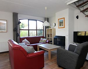 Gezellige woonkamer in Vakantiehuis D 531, De Cocksdorp, Texel. Comfortabele zitruimte met open haard en grote ramen met uitzicht op de natuur.