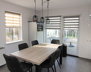 Moderne eetkamer in Vakantiehuis D 481, De Cocksdorp, Texel met ruime tafel en uitzicht op terras.