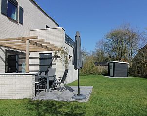 Geniet van de zon op het terras van Vakantiehuis F 609 in De Cocksdorp, Texel, omgeven door groene natuur op de Waddeneilanden.