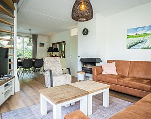 Gezellige woonkamer van Vakantiehuis F 549 in De Cocksdorp, Texel. Comfortabele zithoek met open haard, ideaal voor ontspanning op de Waddeneilanden.