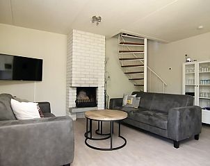 Gezellige woonkamer in Vakantiehuis D 620, De Cocksdorp, Texel met comfortabele banken en open haard voor een ontspannen verblijf op de Waddeneilanden.