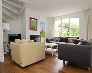 Gezellige woonkamer in Vakantiehuis D 622, De Cocksdorp, Texel. Comfortabele zithoek met uitzicht op de tuin, perfect voor ontspanning.