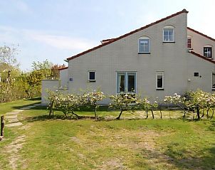 Vakantiehuis D 710 in De Cocksdorp, Texel biedt een prachtig uitzicht op de tuin en rustieke omgeving van de Waddeneilanden.