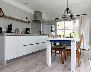 Moderne keuken in Vakantiehuis D 710, De Cocksdorp, Texel. Gezellige eetruimte met uitzicht op de tuin, ideaal voor een ontspannen verblijf.